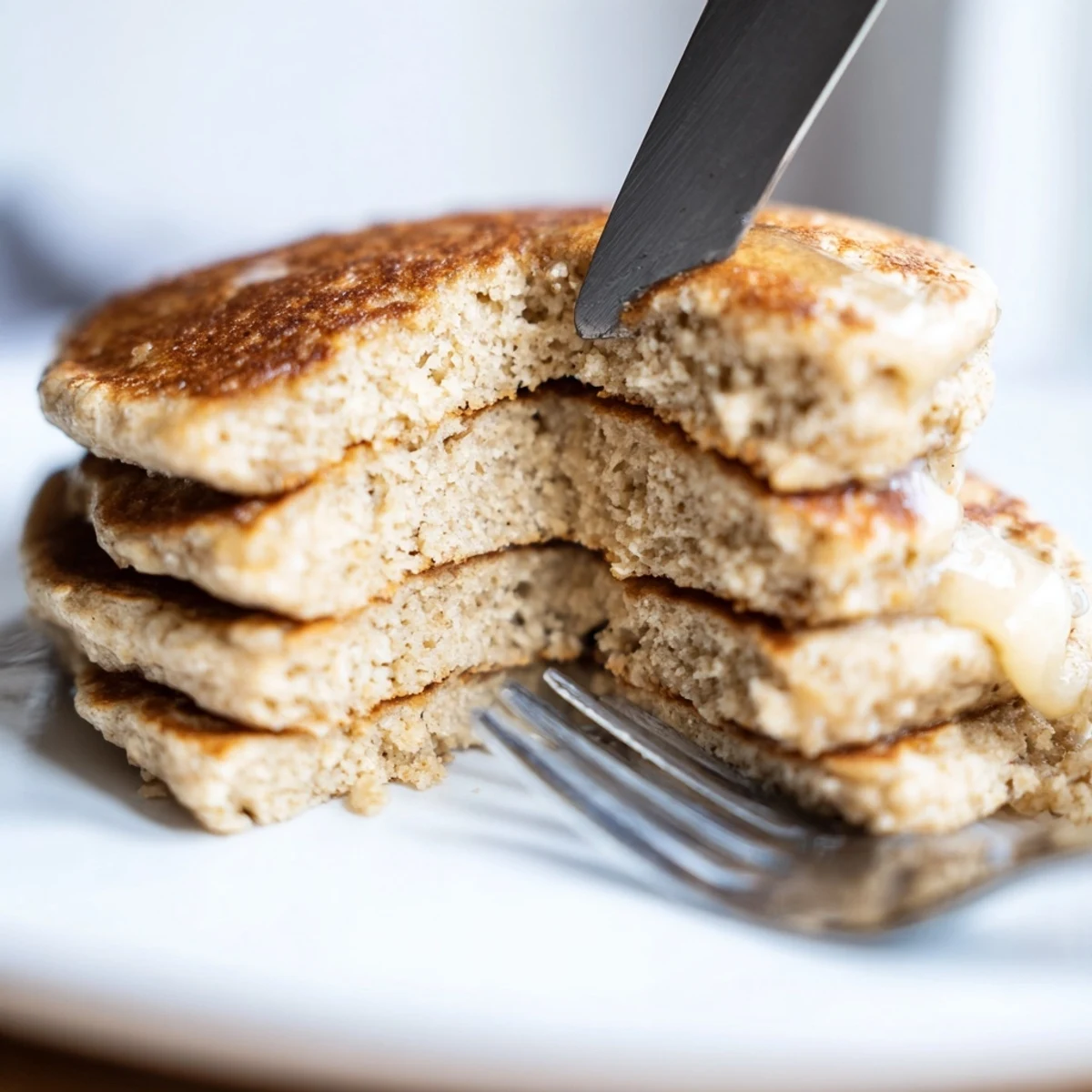 Golden-brown Protein Power Pancakes stacked high, drizzled with maple syrup and topped with fresh berries for a healthy breakfast.