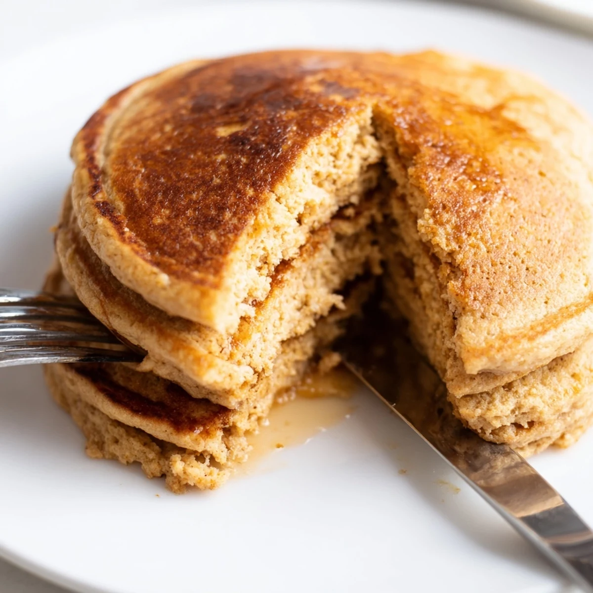 Fluffy Protein Power Pancakes cooking on a griddle, bubbling at the edges and ready to flip to golden perfection.