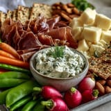 A vibrant Spring Charcuterie Board with radishes, peas, and herb dip, perfect for light entertaining.  