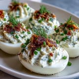 Creamy deviled eggs filled with smoked salmon and topped with everything bagel seasoning, perfect for brunch.
