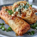 Golden, crunchy spring rolls packed with colorful vegetables and noodles, paired with rich, flavorful peanut sauce for dipping.  