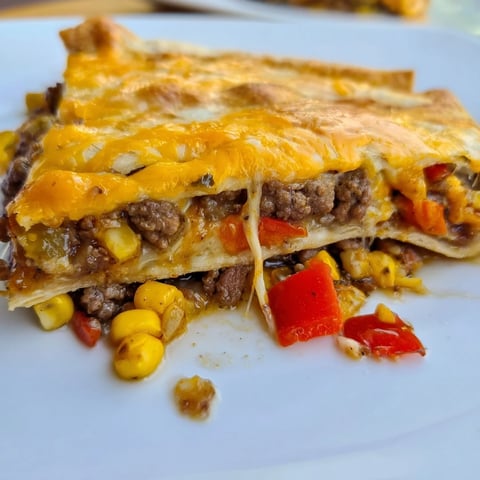 Golden, crispy sheet pan quesadillas filled with melted cheese, savory meat, and colorful veggies.