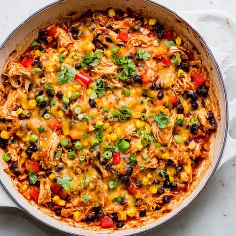 A warm, cheesy Chicken Enchilada Skillet, smelling of cumin, with optional fresh cilantro to add.