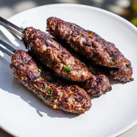 Vibrant image of sizzling Iraqi Kebab Tikka kebabs just off the grill, offering rich, meaty aromas.