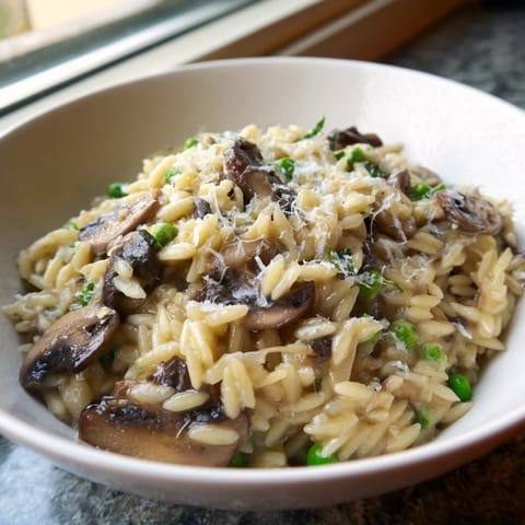 Creamy Orzo Mushroom Risotto-Style pasta simmered with sautéed cremini mushrooms, finished with grated Parmesan and fresh parsley.