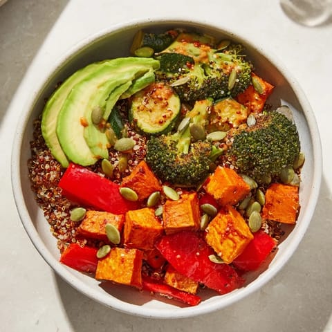 Fluffy quinoa and caramelized vegetables in a colorful Buddha Bowl, garnished with fresh parsley and a generous swirl of tahini lemon dressing.