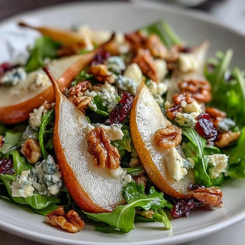 Arugula and Pear Bowl with sliced pears, crumbled cheese, and chopped nuts tossed in balsamic dressing.