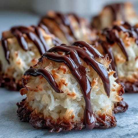 Golden-baked Vegan Coconut Macaroons with Dark Chocolate Drizzle cooling on a parchment-lined tray.