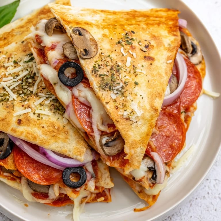Crispy-edged Tortilla Pizza Wrap filled with flavorful pizza toppings and oozing, warm cheese.