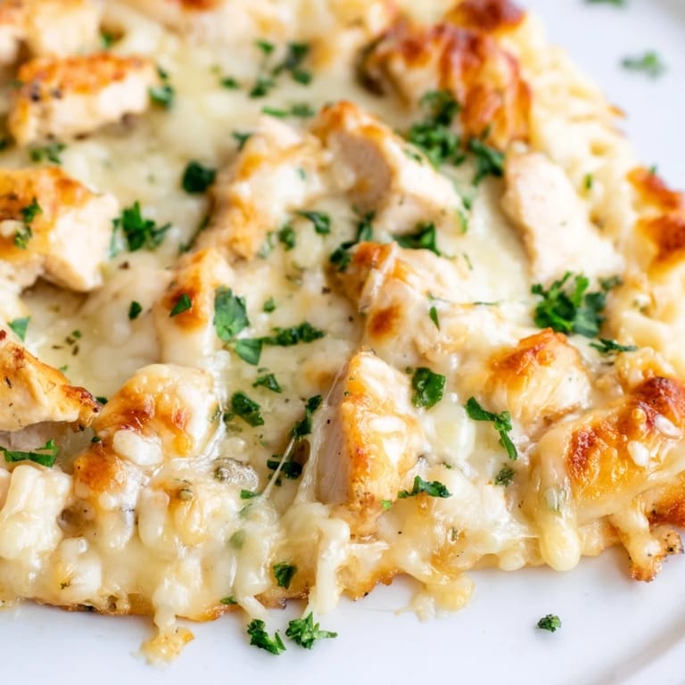 Savory Chicken Alfredo Pizza fresh from the oven, featuring a golden-brown crust and generous layers of mozzarella and Parmesan for a comforting Italian-American meal.