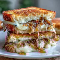 Sourdough French Onion Grilled Cheese Sandwich with caramelized onions and melted Gruyère on crispy sourdough bread.  